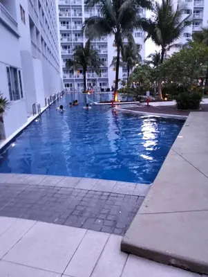 a large swimming pool in the middle of a city at Ellein's Condotel in Manila