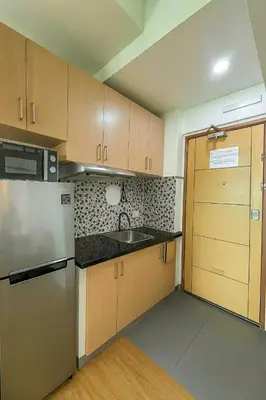 a small kitchen with a sink and a refrigerator at Close by the airports and tourist attractions in Manila