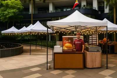 a man standing under a tent with a food stand at The Spot 43 Sunrise in Makati in Manila