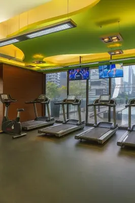 a gym with a row of treadmills at The Spot 43 Sunrise in Makati in Manila