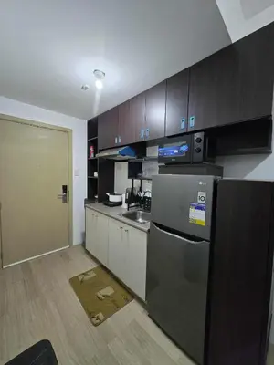 a kitchen with a refrigerator and a sink at SMDC Shine Residence in Manila