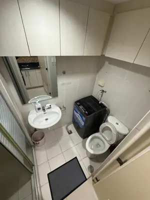a small bathroom with a toilet and a sink at R&K Staycation in Manila