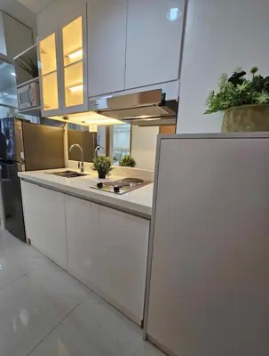 a large kitchen with white cabinets and a sink at Stylish and Glamours Haven in Manila