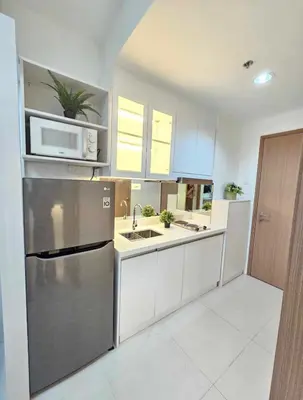 a kitchen with a stainless steel refrigerator and a microwave at Stylish and Glamours Haven in Manila