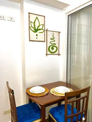 a wooden table with two chairs and two plates on it at Hiraya Pod Staycation Netflix Balcony Beach Escape in Manila