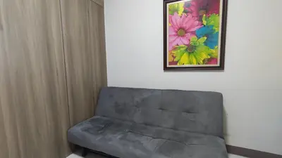 a couch in a room with a painting on the wall at Manila Bay Coast Residences 1BR Flat in Manila