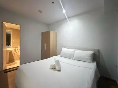 a bedroom with a white bed with towels on it at Minimalist 1 Bedroom Sunset View in Gramercy in Manila