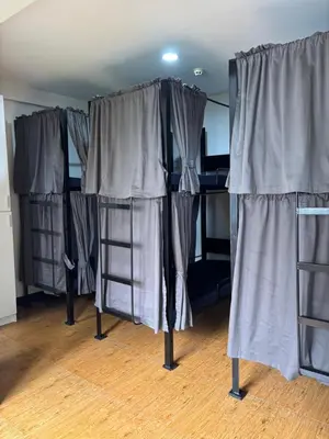 a group of bunk beds in a room with curtains at The Budget Inn in Manila