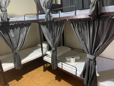 a couple of bunk beds with curtains in a room at The Budget Inn in Manila