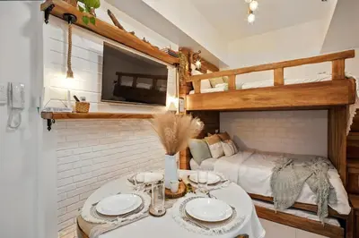 a bedroom with a bunk bed and a table with plates at CABIN STUDIO in KL TOWER, Greenbelt, Makati! Max Capacity 6 pax! in Manila