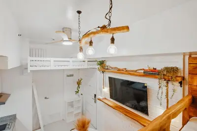 a living room with a tv and a chandelier at CABIN STUDIO in KL TOWER, Greenbelt, Makati! Max Capacity 6 pax! in Manila