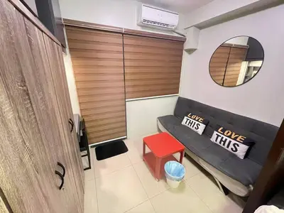 a room with a bench with a mirror and a red stool at Shore 2 tower 2 near moa in Manila