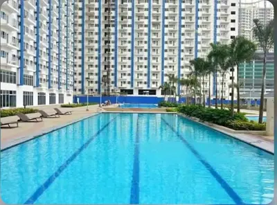 a large swimming pool in front of a large building at Cozy Nook in the City of Mandaluyong in Manila