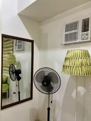 a fan and a mirror in a room at Cozy Nook in the City of Mandaluyong in Manila