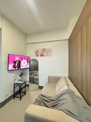 a living room with a couch and a flat screen tv at Stylish City Escape in Manila