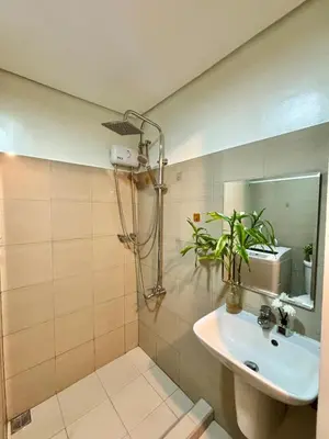 a bathroom with a sink and a shower with a mirror at Chic City Escape by the Bay in Manila