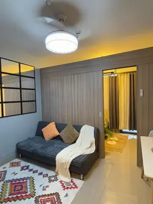 a living room with a couch with a blanket on it at Chic City Escape by the Bay in Manila