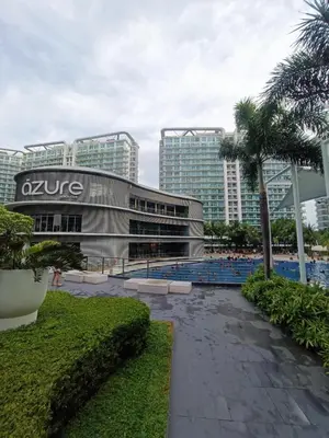 a building with a swimming pool in front of some buildings at Azure Urban Resort Staycation in Manila