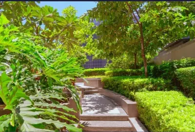 a garden with a stone path and trees and bushes at Uptown Parksuites Upscale Spacious Cor Unit Balcony and Views in Manila