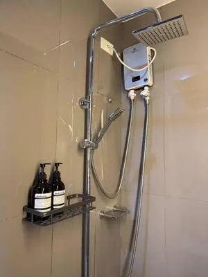 a shower in a bathroom with a soap dispenser at Entire Place in Central Makati in Manila
