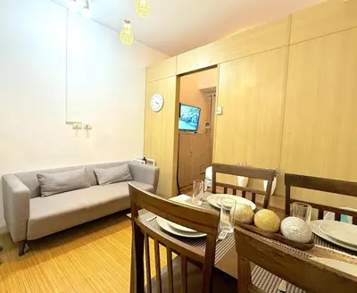 a living room with a table and a couch at Instaworthy Space near BGC NAIA at Grace Res in Manila