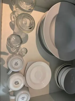 a group of white plates and bowls on a shelf at Modern Condo with Premium Beach View at Azure Urban Resort Residences - Vesta Property in Manila