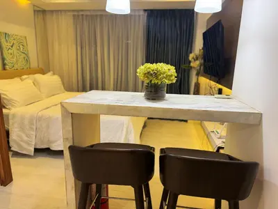 a room with a table with two chairs and a bed at Modern Condo with Premium Beach View at Azure Urban Resort Residences - Vesta Property in Manila