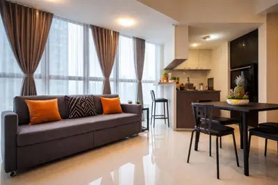 a living room and kitchen with a couch and a table at BGC Family Suite Steps Away from Mall with FREE Parking with Washer Dryer in Manila