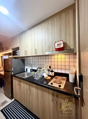 a kitchen with a sink and a refrigerator at ElcaPri Staycation Unit 2 - Shore 2 in Manila