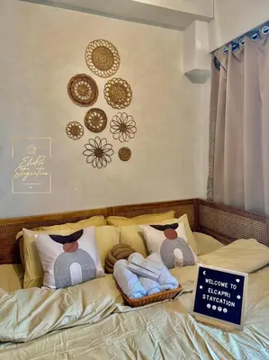 a bed with plates on the wall and a sign on it at ElcaPri Staycation Unit 2 - Shore 2 in Manila