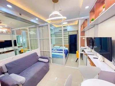 a living room with a purple couch and a bed at shore 2 tower 3 near moa in Manila