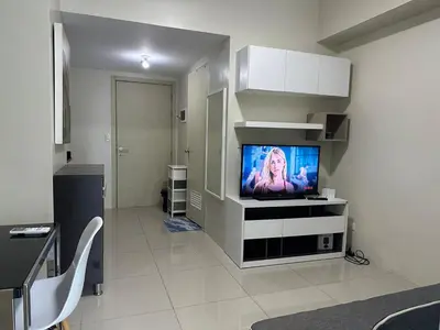 a living room with a flat screen tv on a wall at Bright & Cozy 1 BR in Jazz Residences Tower B in Manila