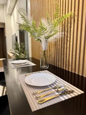 a black table with a plate and a vase of flowers at Jays BnB in Manila