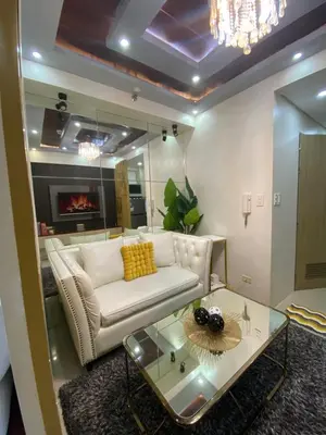 a living room with a white couch and a glass table at MGS Suite Shore 2 Residences in Manila