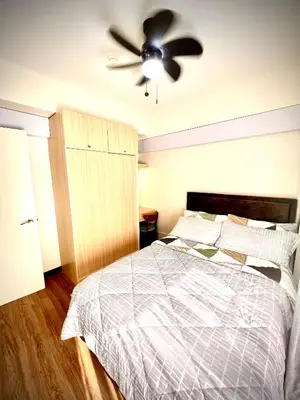 a bedroom with a bed and a ceiling fan at Angels Place The Atherton, Manila Condo Near Airport in Manila