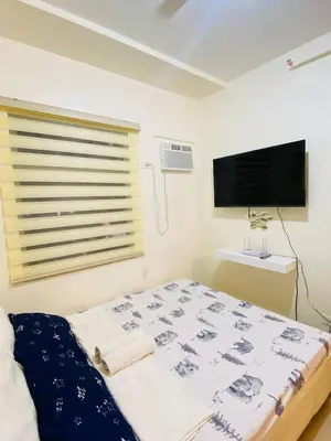 a bedroom with a bed and a flat screen tv at Fully Furnished Studio Type Room for Rent Can be long term or short term in Manila