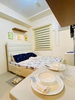 a bedroom with a bed and a table with plates on it at Fully Furnished Studio Type Room for Rent Can be long term or short term in Manila