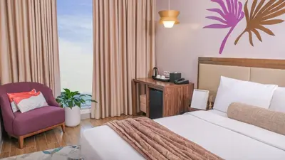 a hotel room with a bed and a purple chair at City Getaway in the Heart of Entertainment City in Manila