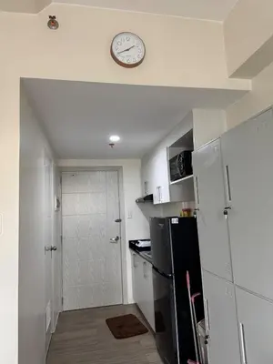 a kitchen with a refrigerator and a clock on the ceiling at Jac's Hide Out 5 in Manila