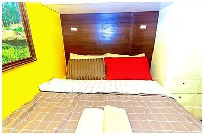 a bedroom with a bed with a red pillow at 2 Bedroom Green Yellow luxury 5549 Makati 300Mb swim in Manila