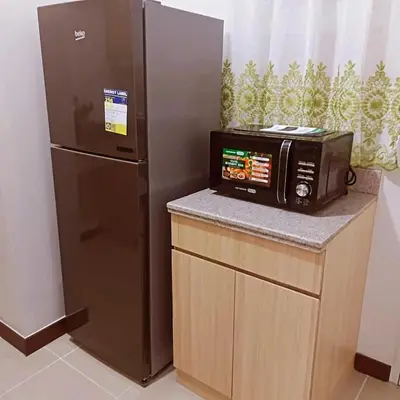 a microwave and a refrigerator in a room at Short stay near NAIA in Manila