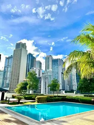 a pool in front of a city with tall buildings at Resort-Style Living in Makati in Manila