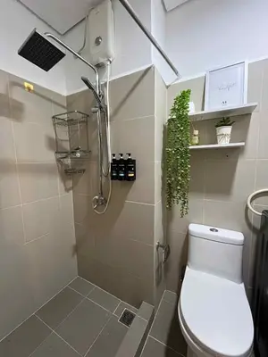 a bathroom with a toilet and a shower with a plant at Casa Florencia at SDMC Coast Residences in Manila