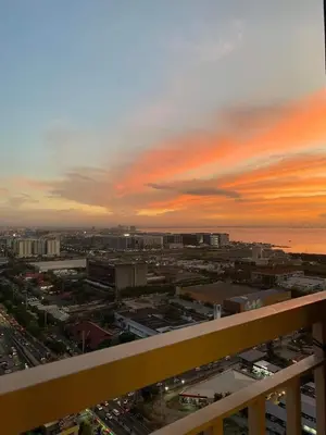 a view from a balcony of a city at sunset at Casa Florencia at SDMC Coast Residences in Manila