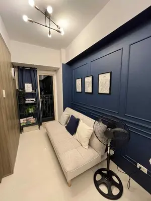 a living room with a couch and a fan at Casa Florencia at SDMC Coast Residences in Manila