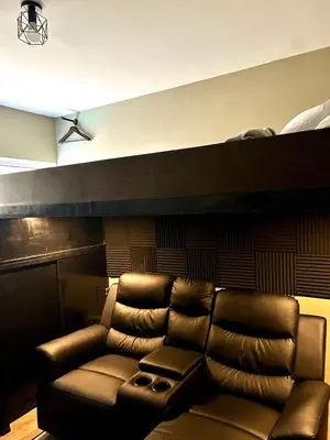 a leather couch in a living room with a ceiling at Cozy Studio near Nuvali, Enchanted Kingdom - Private Cinema with Netflix & Disney Plus with Free Pool Access in Silang