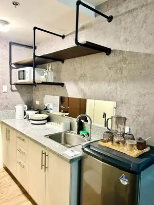 a kitchen with a sink and a counter at Cozy Studio near Nuvali, Enchanted Kingdom - Private Cinema with Netflix & Disney Plus with Free Pool Access in Silang