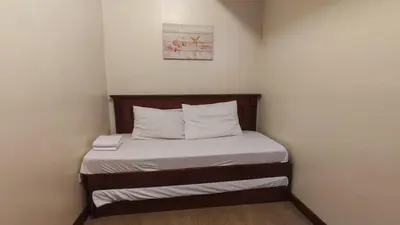 a small bed in a corner of a room at Peaceful 2BR Home in Paranaque Airport Area in Manila