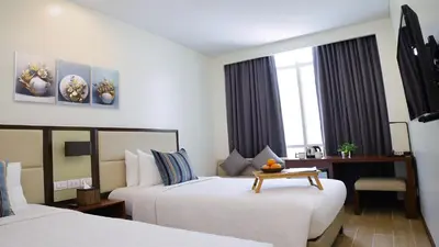 a hotel room with two beds and a table at Private Rooms in Historic Manila Chinatown in Manila