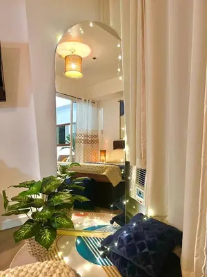 a living room with a mirror and a bed at 15 Mins Away from NAIA Perfect for Staycation in Manila